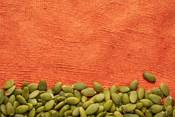 raw pumpkin seed against textured paper