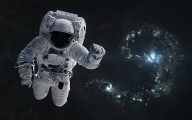 Wall Mural - astronaut on a background of colliding blue galaxies. science fiction. elements of this image furnis