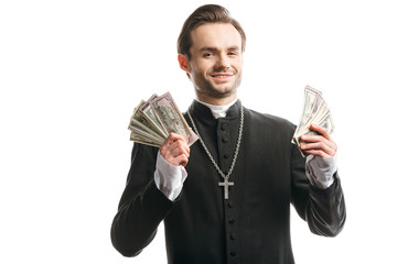 Wall Mural - corrupt catholic priest smiling at camera while holding dollar banknotes isolated on white