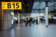 © Michele Ursi - Airport terminal gate with gate number for departing flights, passengers waiting with luggage and suitcase