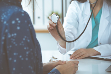 Doctor with a stethoscope in the hand. Physician is ready to examine her female patient.