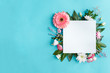 © Monstar Studio - Blank square sheet of paper on blue background. Composition of pink and white flowers are lined with frame around. Greeting card template. Happy mothers, women day, spring, easter concept.