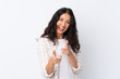 © luismolinero - Mixed race woman over isolated white background pointing to the front and smiling