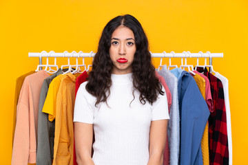 Mixed race woman in a clothing store sad