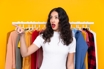 Wall Mural - Mixed race woman in a clothing store pointing away