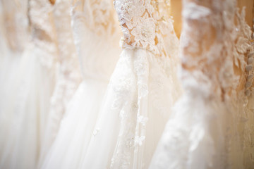 Wedding dress close up at the wedding salon. Wedding dresses hanging on a hanger. Fashion look. Interior of bridal salon.