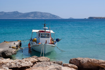 A small fishing boat moored at a jetty, on the beautiful Greek island of Koufonissi.  Crystal clear blue waters and sunshine, at this relaxing and friendly island.