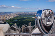 panoramic view of the skyline from  New York City with view over the Manhattan Central Park on a sunny day, in front a blurred zoom binoculars on Rockefeller Center