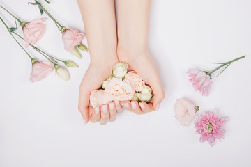 beautiful stylish trendy female pink manicure with flower on background, top view. concept beauty