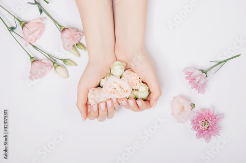Fotografering Beautiful stylish trendy female pink manicure with flower on background, top view