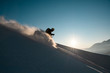 Silhouette of man skier rides down from the snowy hill top