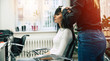 © My Ocean studio - New haircut. Close up side view photo of female hairdresser working with a client in beauty salon.