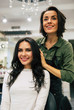 © My Ocean studio - Pretty as a picture. Brunette young women and her hairstylist are looking at her reflection in the mirror in a hairdressing salon.
