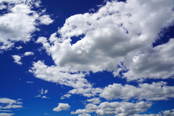 Clear deep blue sky with fluffy white clouds.