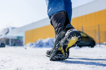 male or female winter boots walking on snowy sleet road