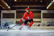 © Dusan Petkovic - Full length of fearless hockey player skating towards goal and trying to make a score. Hall interior. Winter sports.
