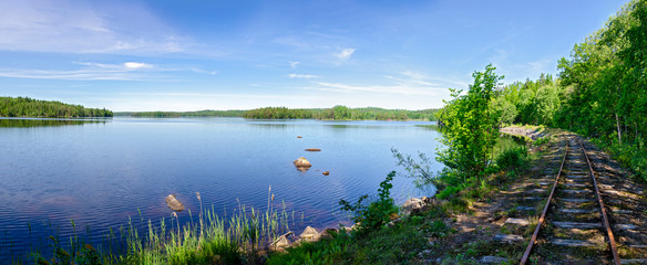 Rusty railway tracks along a lake