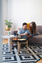 Wall Mural - Cheerful couple looking at mobile phone stock photo