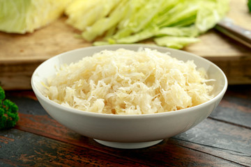 Wall Mural - Fresh pickled cabbage in white bowl on wooden table. healthy food