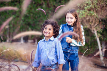 Wall Mural - Two happy kids boy and girl playing outdoor. Childhood and emotions concept.