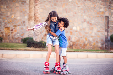 Wall Mural - Two happy kids boy and girl roller skate in the park. Children and activity concept