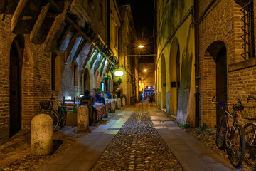 Fototapete - Cozy street with old houses in Ferrara, Emilia-Romagna, Italy. Ferrara is capital of the Province of Ferrara.