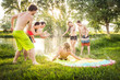 © MACO - Group of young adults having fun in a swimming lake with a slip and slide. Bridger, Montana, USA