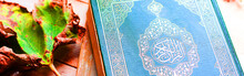Holy Book Quran And Leaves On Wooden Table