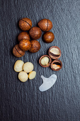 Sticker - Macadamia nuts with a cleaning key lie on a black slate. Top view, copy space.