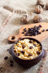 Wall Mural - Sweet millet porridge with dark raisins in ceramic rustic bowl