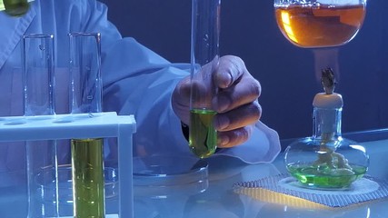 Wall Mural - scientist holding flask with lab glassware and test tubes in chemical laboratory background, science