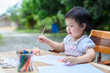 © apiwat - Cute little Asian girl in a white dress is drawing with painting fun