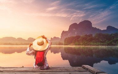 Wall Mural - Traveler woman joy looking beautiful sunrise view reflection nature mountain landscape on lake, Lifestyle adventure travel Krabi Phuket Thailand, Tourism destination Asia, Summer holiday vacation trip