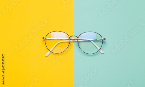Fotomural Eye glasses isolated on yellow and blue background.