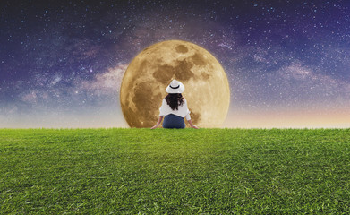 Wall Mural - woman sitting alone at night under full moon and starry sky