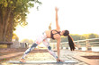 © ty - Athletic girl is doing advanced yoga asana on the fitness mat outdoors.