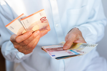 Female woman hand holds out a pack of euro close up, finance business concept.