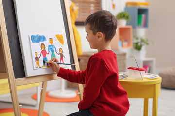 Poster - Little child painting on easel in room