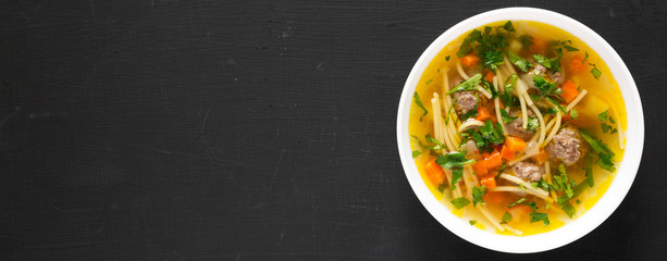 Homemade Sopa a La Minuta in a white bowl on a black background, top view. Flat lay, overhead, from above. Copy space.