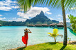 Tahiti travel holiday luxury hotel vacation tourist woman walking on Bora Bora island beach with view of Mt Otemanu in French Polynesia. High end resort with overwater bungalows villas.