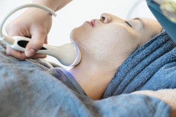 Wall Mural - Female receiving Anti-Aging cosmetics using ultrasound cavitation machine.