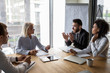 © fizkes - Arabian and aged businesspeople talking during business negotiations in office