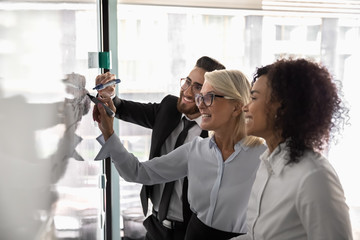 Three diverse entrepreneurs working on business strategy using white board