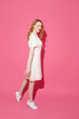 © Northern life - Beautiful fashionable young blonde woman posing in a studio, summer dress. Long wavy hairstyle. Bright pink background. Trendy feminine summer photo.