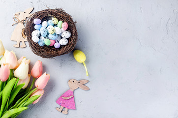 Wall Mural - Easter background with colored Decorative eggs in the nest and tulips