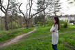 © indigolotos - Charming young woman in white cardigan.