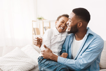 Wall Mural - Genuine emotions. African dad tickling cute daughter