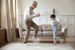 © fizkes - Overjoyed older senior grandfather dancing with excited little grandson.
