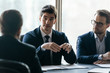 © fizkes - Confident businessman discuss project sit at table in boardroom.