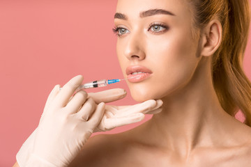 Wall Mural - Pretty Girl Receiving Beauty Injection In Lips Over Pink Background